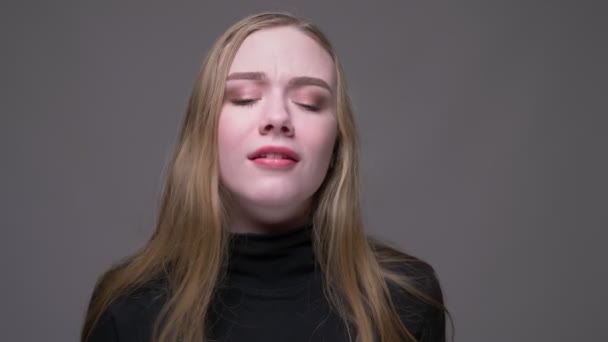 Close-up portret van jonge aantrekkelijke brunette vrouwelijke dansen met vreugde kijken naar camera met achtergrond geïsoleerd op grijs — Stockvideo