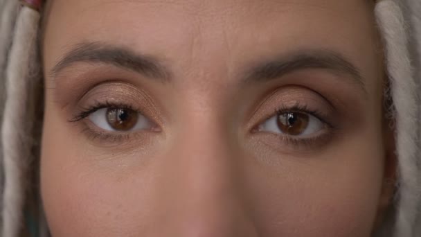 Closeup olhos atirar de jovem atraente caucasiano hipster fêmea com dreadlocks loira olhando diretamente para a câmera — Vídeo de Stock