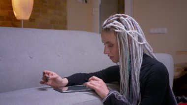 Rahat bir dairede kapalı kredi kartı ile tablet online dreadlocks alışveriş ile genç çekici kafkas hipster kadın Closeup ateş