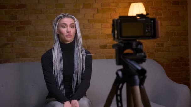 Närbild shoot av unga attraktiva kvinnliga bloggare streaming live Talking på kameran sitter på soffan inomhus — Stockvideo