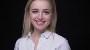 Beyaz gömlekli genç ve güzel iş kadınının fotoğrafı kameraya döner ve siyah arka planda çok mutlu olur.