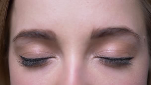 Close-up eye shoot of young businesswoman watches into camera being very glad and happy on black background. — Stock Video