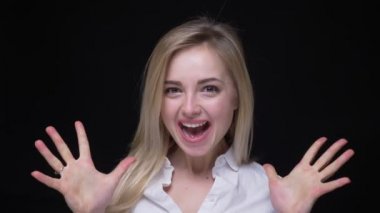 Beyaz gömlekli güzel ve genç iş kadını ellerini çırpıyor ve siyah arka planda saç sallıyor son derece mutlu oluyor.