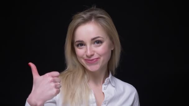 Vrolijke jonge zakenvrouw in wit overhemd geeft een duim-up om te laten zien als en respect op zwarte achtergrond. — Stockvideo