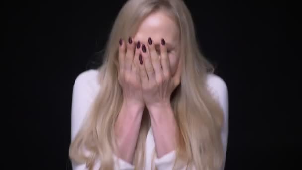 Closeup portrét mladé blondýny ženy, která je překvapená a oslavuje pohled na kameru s pozadím izolovaným na černém — Stock video