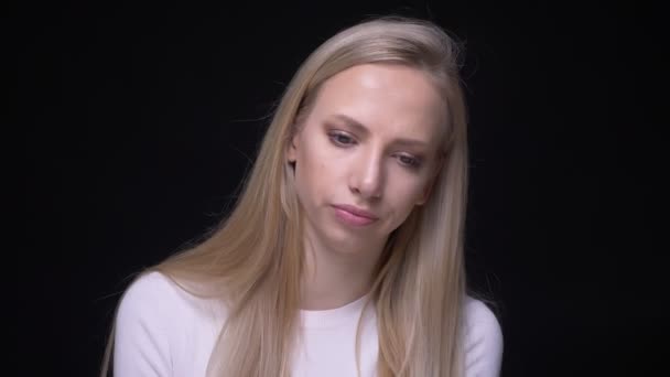 Close-up portret van jonge mooie blonde vrouw is boos en gefrustreerd kijken naar camera met achtergrond geïsoleerd op zwart — Stockvideo