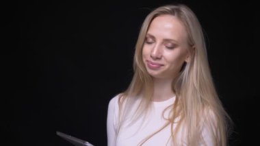 Tablet kullanarak genç güzel sarışın kadın Closeup portre ve siyah izole arka plan ile kamera bakarak yeşil ekran gösteren