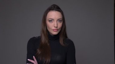 Kollarını çapraz olan esmer saçlı yetişkin çekici beyaz kadın Closeup portre gri izole arka plan ile kameraya bakarak çapraz