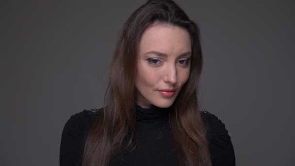 Nahaufnahme Porträt eines Erwachsenen attraktive kaukasische Frau lächelnd mit Schüchternheit Blick auf Kamera mit Hintergrund isoliert auf grau — Stockvideo