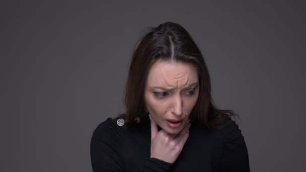 Retrato de primer plano de una mujer caucásica atractiva adulta que tiene una garganta enferma y tos con fondo aislado en gris — Vídeos de Stock
