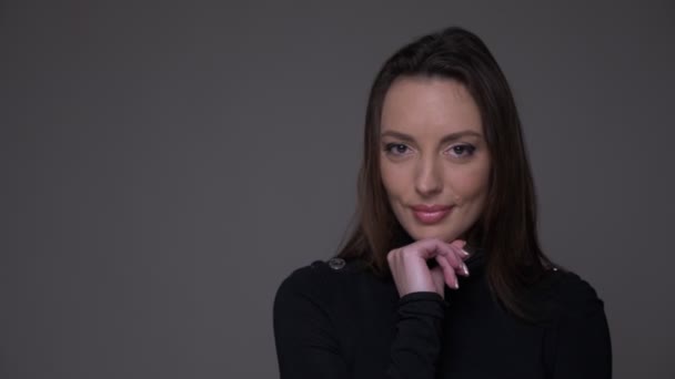 Portrait rapproché d'une femme caucasienne adulte souriante regardant la caméra avec un arrière-plan isolé sur gris — Video