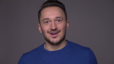 Genç yakışıklı beyaz adam yakın çekim heyecanlı ve sürpriz mutlu gri izole arka plan ile kameraya bakarak kutluyor