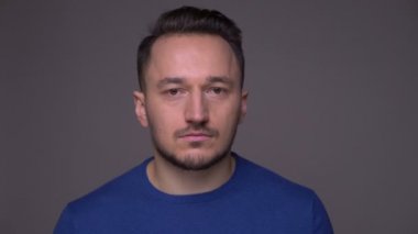 Genç yakışıklı beyaz adam yakın çekim kızgın ve gri izole arka plan ile kameraya bakarak rahatsız