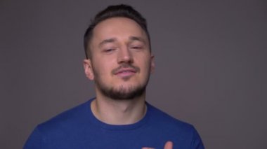 Genç yakışıklı beyaz adam dans ve mutlu gri izole arka plan ile kameraya bakarak gülümseyen closeup ateş