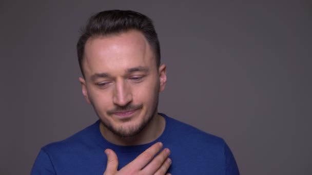 Closeup shoot of young handsome caucasian man having a sick throat and being ill with background isolated on gray — Stock Video