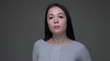 Genç güzel beyaz kadın poz ve gri izole arka plan ile kameraya bakarak Closeup ateş