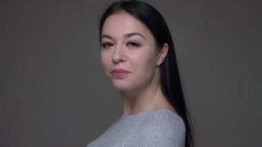 Genç güzel beyaz kadın dönercloseup ateş gri izole arka plan ile mutlu bir şekilde gülümseyerek kameraya bakarak