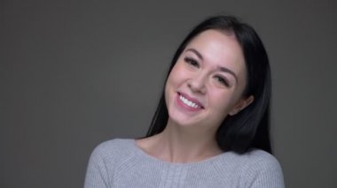 Genç güzel esmer kafkas kadın closeup ateş heyecanlı ve neşeli gri izole arka plan ile kameraya düz bakarak