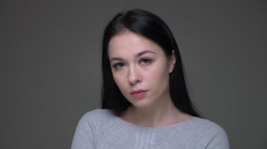 Genç üzgün esmer beyaz beyaz kadın yakın çekim üzgün ve depresif gri izole arka plan ile kamera düz bakarak