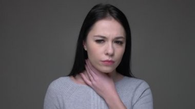 Genç güzel esmer beyaz kadın hasta bir boğaz olan ve gri izole arka plan ile hasta olmak Closeup ateş