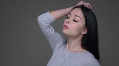 Gri izole arka plan ile kamera önünde poz genç güzel esmer kafkas kadın modelcloseup ateş