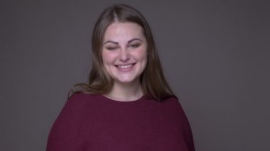 Genç kilolu beyaz kadın closeup portarit neşeyle gri izole arka plan ile kameraya bakarak gülümseyerek