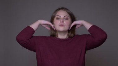 Genç kilolu beyaz kadın modelin closeup portarit poz ve arka plan gri izole ile kamera bakıyor