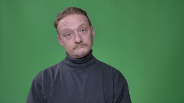 Hombre de mediana edad con barba y bigote escuchando y asintiendo emocionalmente sobre fondo verde . — Vídeos de Stock