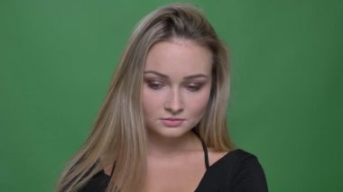 Siyah bluz genç iş kadını portresi ciddi ve sabit yeşil arka planda kamera içine izlerken.