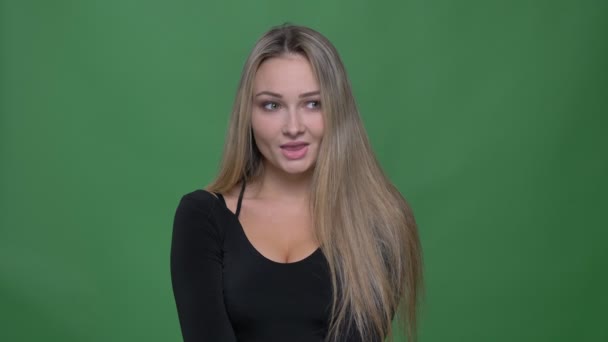 Retrato de una joven empresaria en blusa negra tímidamente pensando y sonriendo al fondo verde . — Vídeos de Stock