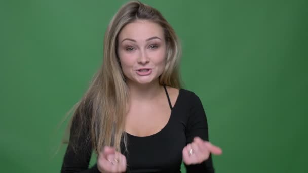 Портрет молодой предпринимательницы в черной блузке, смеющейся и активно разговаривающей с камерой на зеленом фоне . — стоковое видео