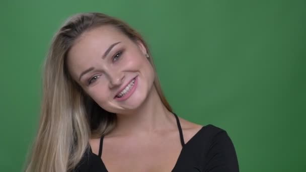 Retrato de una joven empresaria en blusa negra sonriendo a cámara en un fondo verde . — Vídeos de Stock