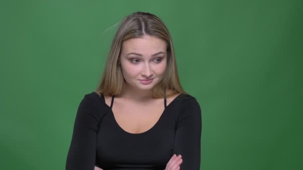 Geschäftsfrau in schwarzer Bluse dreht bei grünem Hintergrund negativ den Kopf in die Kamera. — Stockvideo