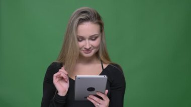 Yeşil arka planda uygulama tavsiye tablet mavi ekran gösteren siyah bluz joyful iş kadını.