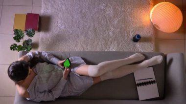 Sevimli çorap kanepede oturan yeşil renk ekran ile telefonda sohbet genç çekici kadın genç Closeup üst ateş