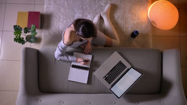 Closeup Top lő fiatal vonzó női segítségével a laptop és tanul ül a padlón aranyos zoknit beltéri egy hangulatos lakás — Stock videók