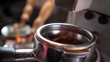 Kahve çekirdeklerinin kapalı bir kafede kahve karıştırma makinesinde taze öğütüldüğü yakın çekim
