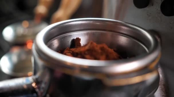 Съемки крупным планом кофейных зерен, недавно смешавшихся в кофемолке в помещении кафе — стоковое видео
