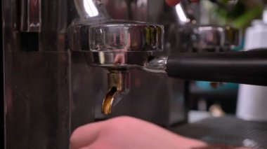 Üç bölmeli lavabo kullanarak bir kahve yapma ve kapalı bir kafede gümüş sürahi içine bir içki dökme barsita Closeup ateş