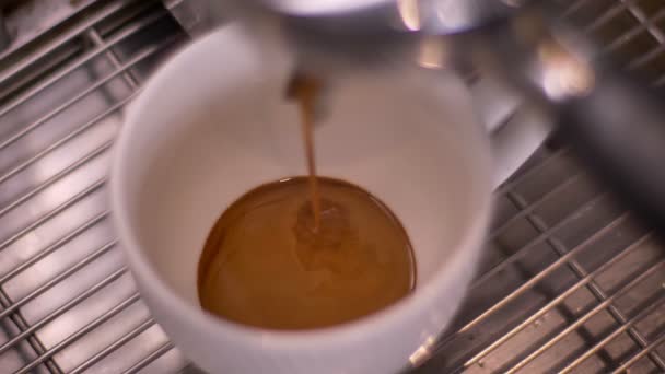 Съемки кофе крупным планом, выливающегося в чашку с помощью раковины из трех отсеков в ресторане — стоковое видео