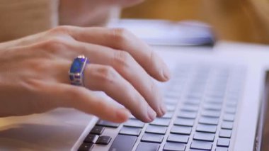 Rahat bir kahve dükkanında kapalı dizüstü bilgisayarda yazarak kadın ellerin Closeup yan görünüm ateş