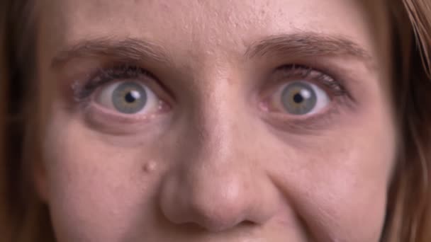 검은 배경에 긍정적 인 놀이에 그녀의 눈을 돌출 귀여운 금발 모델의 클로즈업 초상화. — 비디오