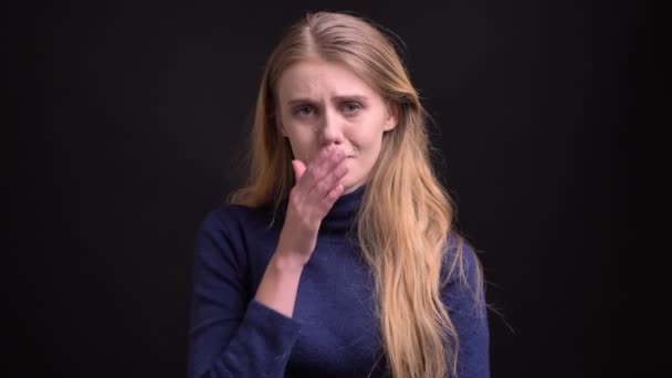 Retrato de la joven modelo rubia deprimida con pelo peludo mirando miserablemente en la cámara sobre fondo negro . — Vídeos de Stock