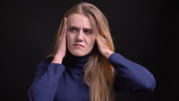 Portret van ellendigbaar jong blond model met fuzz Hair lijden van verschrikkelijke migraine op zwarte achtergrond. — Stockvideo
