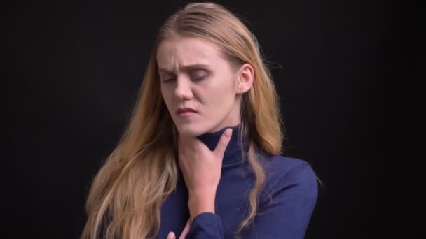 Portret van triest jong blond model met fuzz Hair lijdt aan keelpijn en hoesten op zwarte achtergrond. — Stockvideo