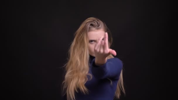 Beschwingtes junges blondes Model in blauem Pullover tanzt fröhlich und aktiv auf schwarzem Hintergrund. — Stockvideo