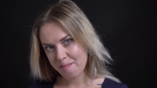 Feliz mujer de negocios rubia de mediana edad en blusa azul posando y coqueteando con la cámara sobre fondo negro . — Vídeos de Stock