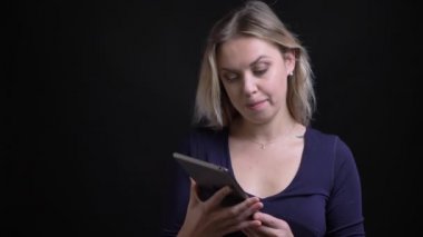 İş kadını tablette uygulamayı açar ve siyah arka planda kameraya neşeyle yeşil ekran gösterir.