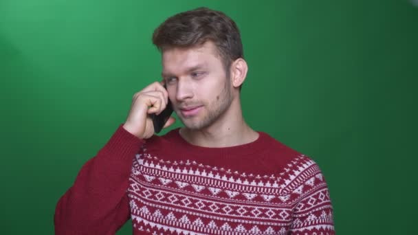 Gelukkig jonge brunette zakenman praten op mobiele telefoon wordt vrolijk en blij op groene achtergrond. — Stockvideo