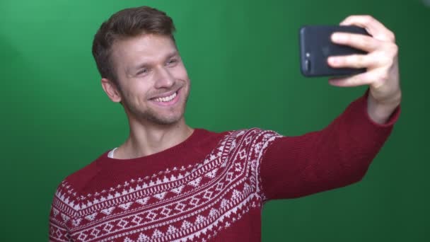 Gioioso uomo d'affari fa selfie su smartphone con sorriso positivo su sfondo verde . — Video Stock